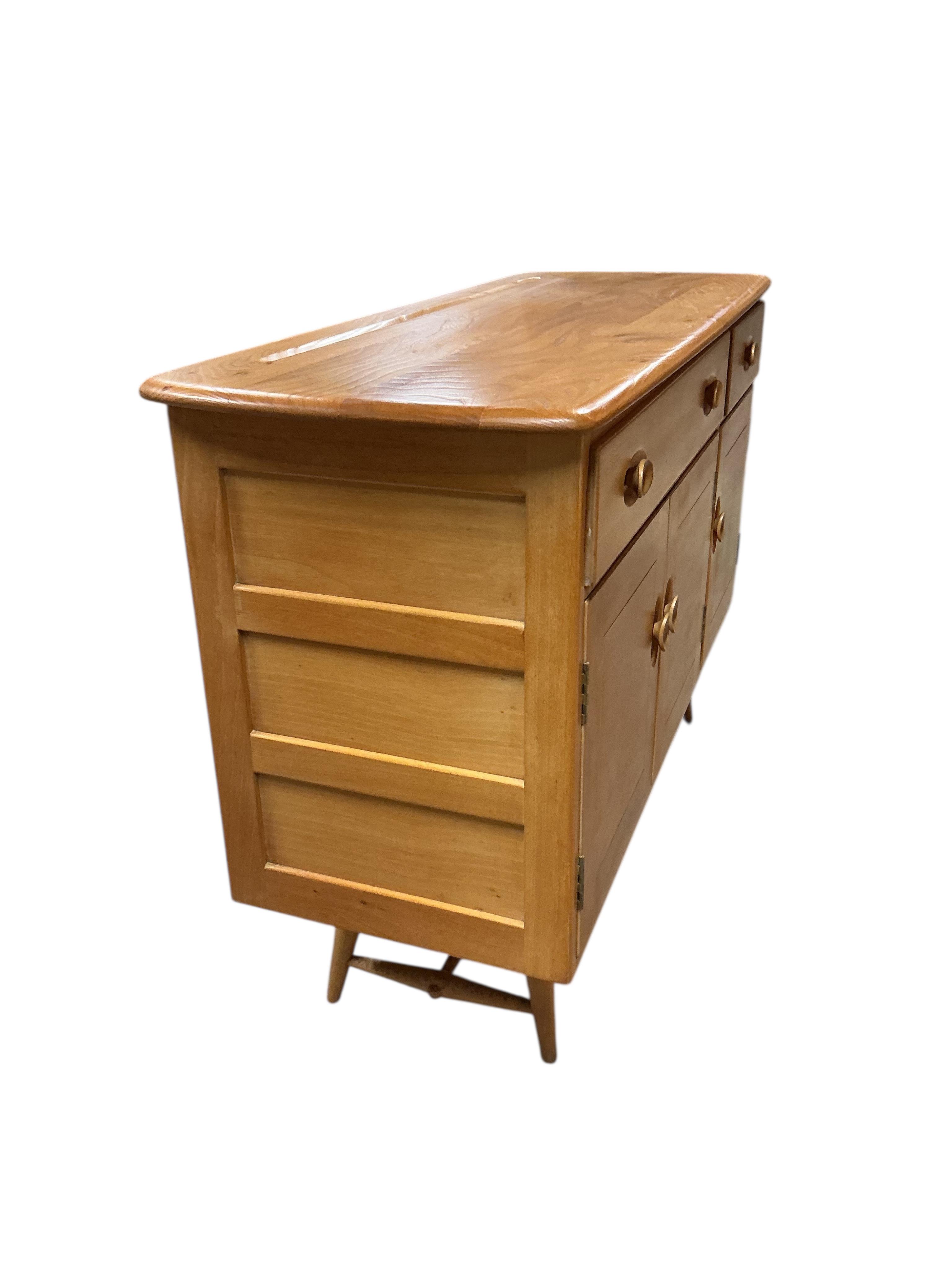 An Ercol elm and beech rectangular dining table, width 150cm, 75cm, height 72cm, together with a set of six Ercol elm and beech comb back dining chairs, two with arms and an Ercol style sideboard